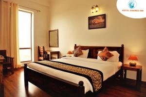 a bedroom with a large bed in a room at Hotel Orange inn Kodaikanal in Kodaikānāl