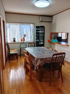 a dining room with a table and a dog sitting on a window at 一棟貸切ゲストハウスかた籠 in Kamikawa