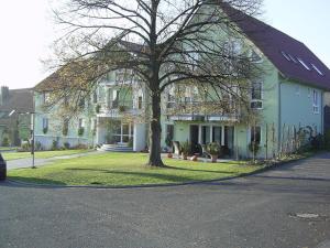 une grande maison blanche avec un arbre en face dans l'établissement Wein-Träume, à Thüngersheim