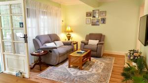 a living room with two chairs and a couch and a table at Curtis Falls Studio-Apartment in Mount Tamborine