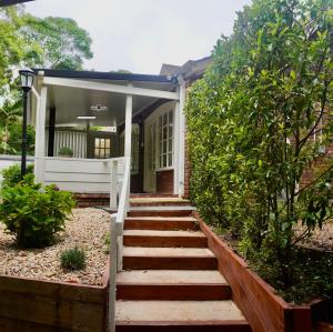 a house with stairs leading to the front door at Curtis Falls Studio-Apartment in Mount Tamborine
