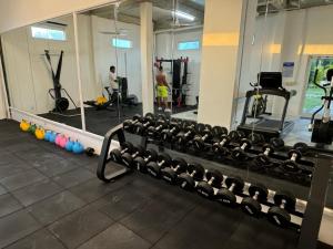 a gym with a rack of dumbbells and a mirror at The Beach Resort in Koh Rong Island