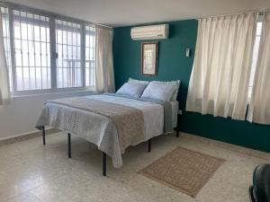 Un dormitorio con una cama con paredes y ventanas azules. en Casa Luna Suites-4, en Monterrey