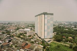 a tall building in the middle of a city at Modern Classic Studio at Loftvilles City Apartment By Travelio in Tangerang