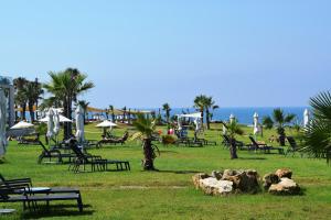 a park with chairs and umbrellas on the beach at Amphora Hotel & Suites in Paphos