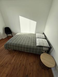 a bedroom with a bed and a wooden floor at Maison de ville - Chez Marsou in Poitiers
