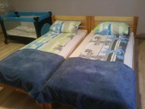 2 Betten nebeneinander in einem Zimmer in der Unterkunft Kwatera Na Rogu in Augustów