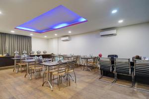 a dining room with tables and chairs and a blue ceiling at Hotel Noida Express in Noida