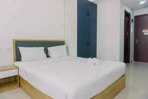 a bedroom with a large white bed with white pillows at Good Deal and Homey Studio Pacific Garden Apartment By Travelio in Tangerang +8 photos