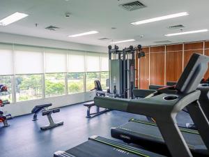 a gym with treadmills and ellipticals and windows at Good Deal and Homey Studio Pacific Garden Apartment By Travelio in Tangerang