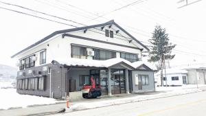 a house with a red tractor in front of it at See 遊 in HAKUBA 和楽 in Hakuba