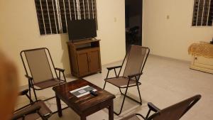 a living room with chairs and a table and a tv at San Bernardino 2 in Valladolid