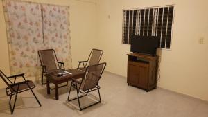 a living room with three chairs and a television at San Bernardino 2 in Valladolid