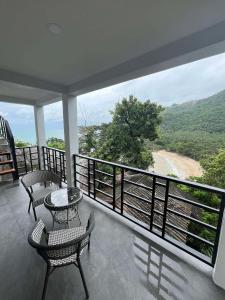 a balcony with chairs and a table and a view at Silver Cliff Room 16 in Than Sadet Beach +2 photos