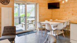a dining room with a table and chairs and a balcony at Chalet les Estives au pied des pistes, le lioran, terrasse, 2 chambres, 4 lits in Laveissière +24 photos