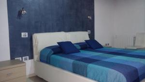 a bedroom with a blue and white bed with blue pillows at Antico Centro Quartu in Quartu SantʼElena