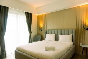Postel nebo postele na pokoji v ubytování Well Furnished and Elegant 1BR at Bintaro Embarcadero Apartment By Travelio