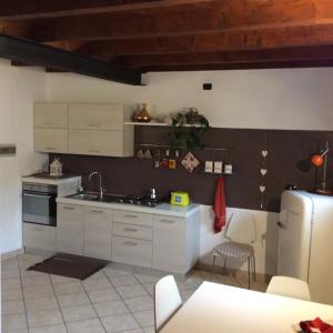 a kitchen with white cabinets and a refrigerator at Borghello 2Level Airport in Bergamo