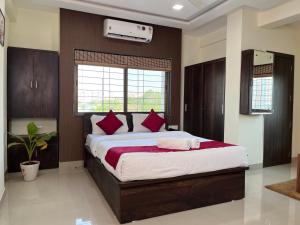 DāpuriHotel Bramha Inn Aundh Wakad Rooms Restaurant Banquet的卧室里有一张大床，配有红色枕头
