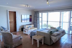 a living room with a couch and chairs in a room at Bayside Cottage in Cape Town