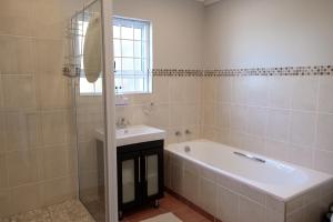 a bathroom with a bath tub and a sink at Bayside Cottage in Cape Town +34 photos
