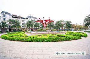 a fountain in a park with palm trees and buildings at Merci Vinhomes Imperia Hai Phong in Hai Phong