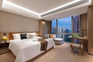 a bedroom with a large bed and a large window at Somerset Wanxia Shenzhen in Shenzhen