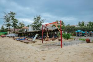 a group of people sitting on the beach at Le Aqua Resort & Spa Phan Thiet - Swiss Village Resort & Spa in Mui Ne