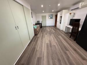 a living room with a hard wood floor at Comfortable studio in Bowen 4805 in Bowen +1 photo