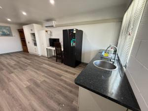 a kitchen with a sink and a black refrigerator at Comfortable studio in Bowen 4805 in Bowen