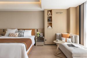 a hotel room with two beds and a chair at Somerset Wanxia Shenzhen in Shenzhen