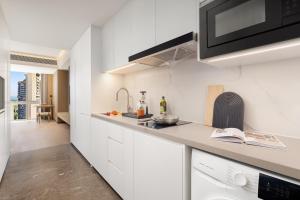 a kitchen with white cabinets and a counter top at Somerset Wanxia Shenzhen in Shenzhen