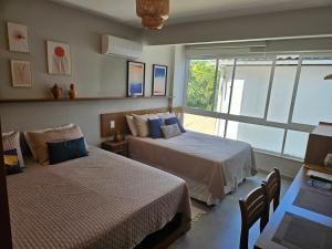 a bedroom with two beds and a large window at Contemporâneo Absolute e piscina com borda infinita in Morro de São Paulo +8 photos