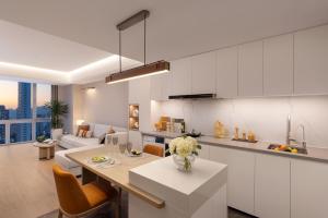 a kitchen and living room with white cabinets at Somerset Wanxia Shenzhen in Shenzhen