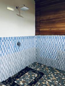 Camera con parete piastrellata e doccia. di Bintang Homestay a Tetebatu