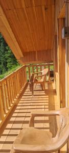 a wooden porch with a bench and a table at VistaVibes in Sainj