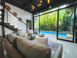 a living room with a couch and a large window at Villa Habibi in Uluwatu