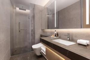 a bathroom with a shower and a sink and a toilet at Somerset Wanxia Shenzhen in Shenzhen