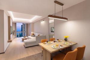 a dining room and living room with a table and chairs at Somerset Wanxia Shenzhen in Shenzhen