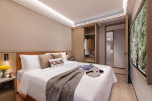 a bedroom with a large white bed in a room at Somerset Wanxia Shenzhen in Shenzhen