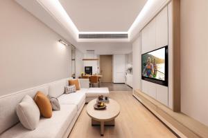 a living room with a couch and a tv at Somerset Wanxia Shenzhen in Shenzhen