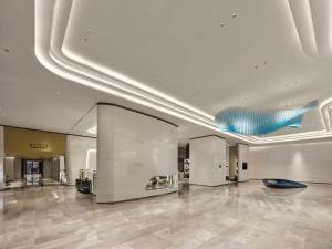 a large room with a lobby with a blue ceiling at Hilton Shanghai Hongqiao International Airport in Shanghai