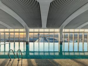 an indoor swimming pool in a building with windows at Hilton Shanghai Hongqiao International Airport in Shanghai