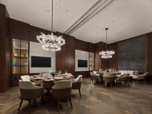 a dining room with tables and chairs and chandeliers at Hilton Shanghai Hongqiao International Airport in Shanghai