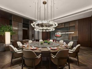 a dining room with a table and chairs and a chandelier at Hilton Shanghai Hongqiao International Airport in Shanghai