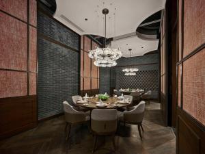 a dining room with a table and chairs and a chandelier at Hilton Shanghai Hongqiao International Airport in Shanghai