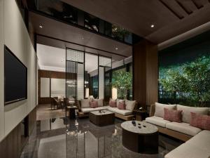 a living room with couches and tables and a tv at Hilton Shanghai Hongqiao International Airport in Shanghai