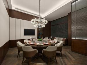 a dining room with a table and chairs and a chandelier at Hilton Shanghai Hongqiao International Airport in Shanghai