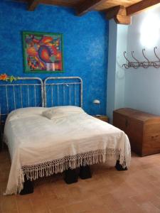 a bedroom with a bed with a blue wall at Casavacanze Ciaspole E Uva in Fiastra
