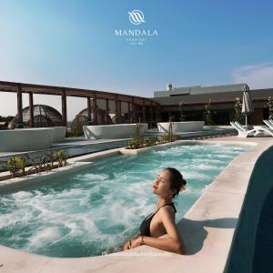 une femme assise dans une piscine dans l'établissement Heaven Dreamscape Hotel, à Mui Ne
